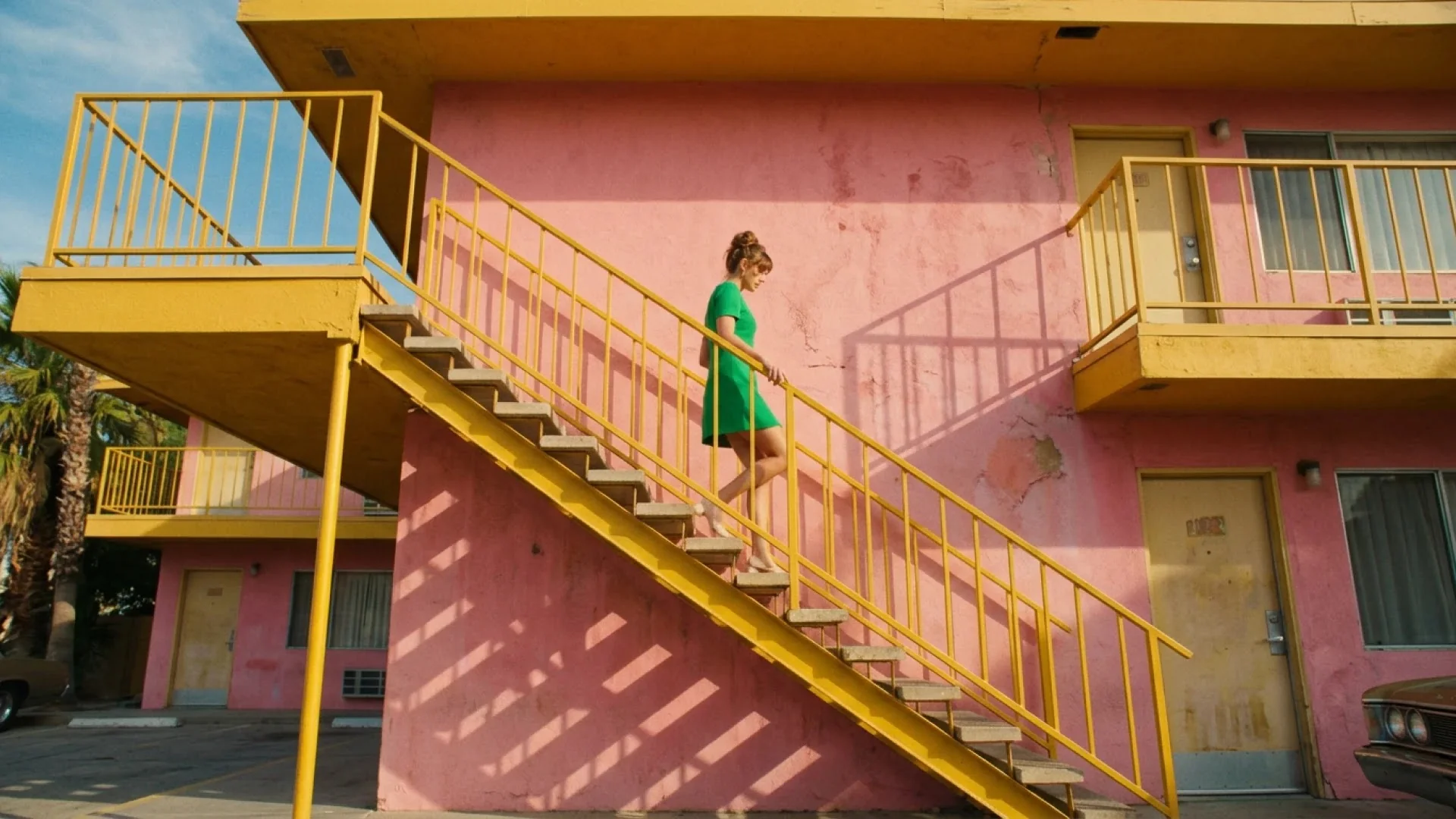 Google official Nano Banana 2.1 example: woman in a green dress walking down a yellow motel staircase